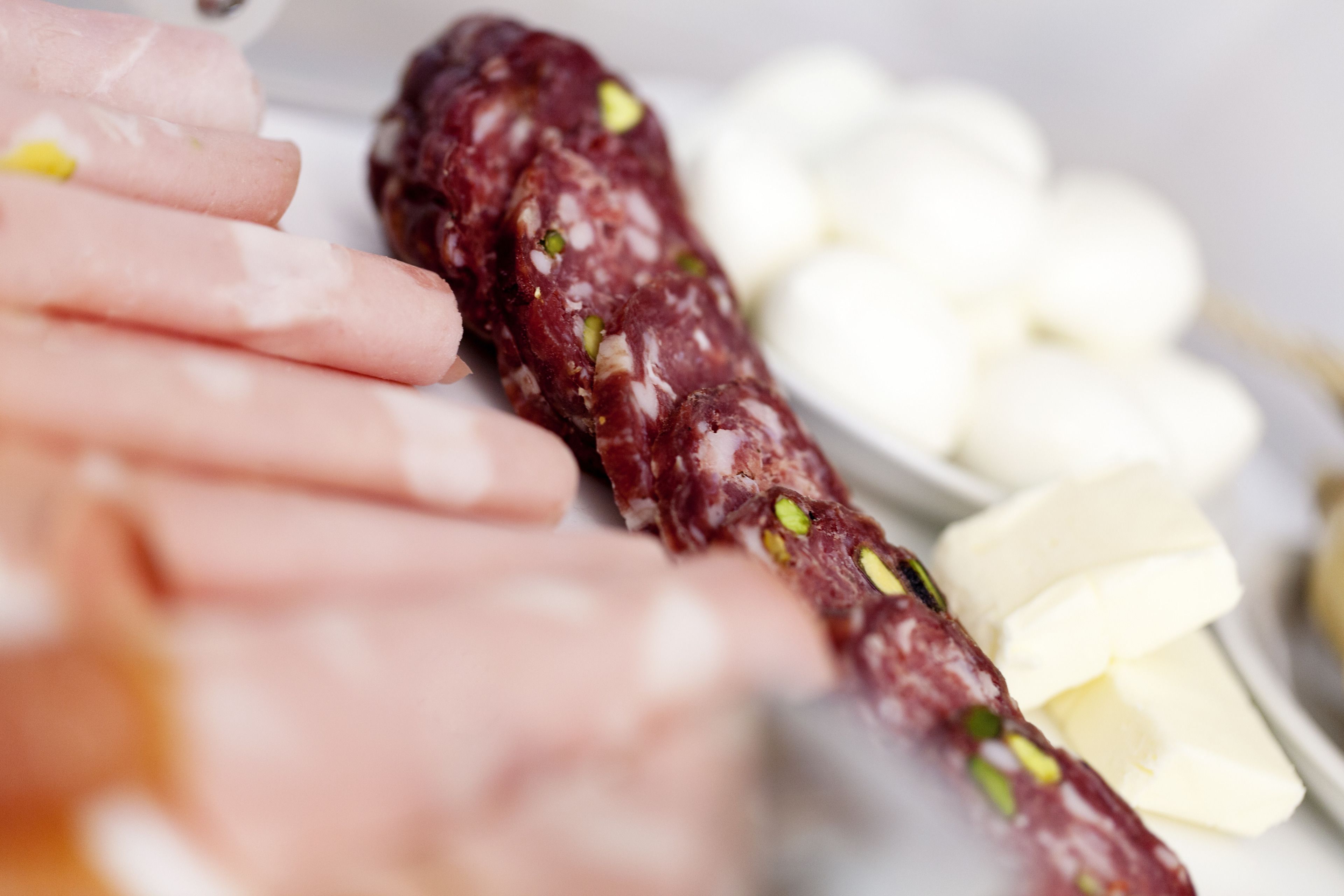 A variety of cured meats and cheeses on a plate.