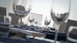A dining table set with wine glasses, cutlery, and plates, suggesting a formal dining setting. - AH Premium Isola di Pazze (Ugento)