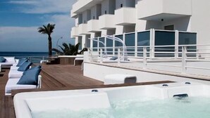 A modern hotel with a pool area, multiple balconies, and a view of the ocean. - AH Premium Isola di Pazze (Ugento)
