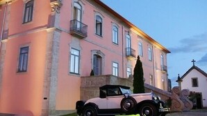 A pink building with a balcony and a vintage car parked in front. - Hotel Rural Quinta Da Cruz (Amarante)
