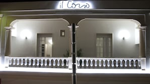 A building facade with a sign reading "il Corso" and a balcony with a railing. - Il Corso (Porto Cesareo)