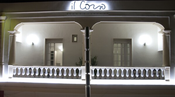 A building facade with a sign reading "il Corso" and a balcony with a railing. - Il Corso (Porto Cesareo)
