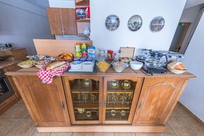 A wooden buffet table with various food items and kitchenware.