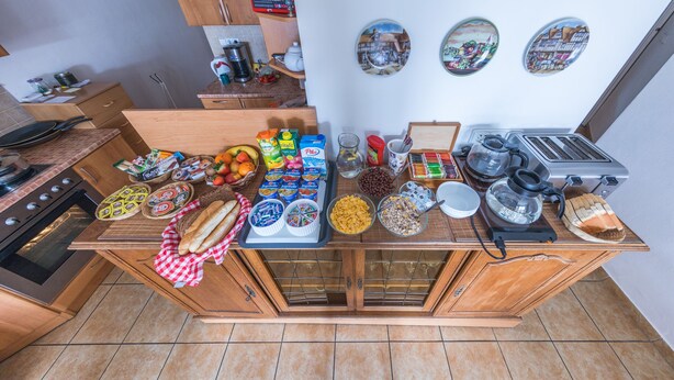A kitchen counter with various food items and kitchen appliances. - Pension Nika (Prague)