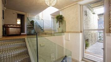 Un intérieur moderne avec un escalier, un canapé en cuir et une plante en pot.