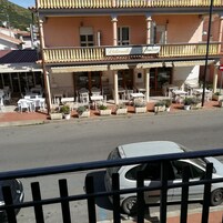 Un restaurante con terraza al aire libre, techo de tejas y un letrero que dice 