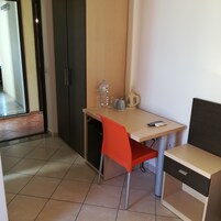 Un espacio de oficina pequeño y moderno con un escritorio, una silla y una máquina de café.