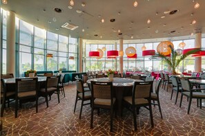 Enjoy meals in a spacious dining area with high ceilings, pendant lights, and large windows.