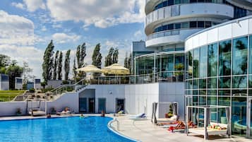 Piscine couverte, piscine extérieure, parasols de plage, chaises longues