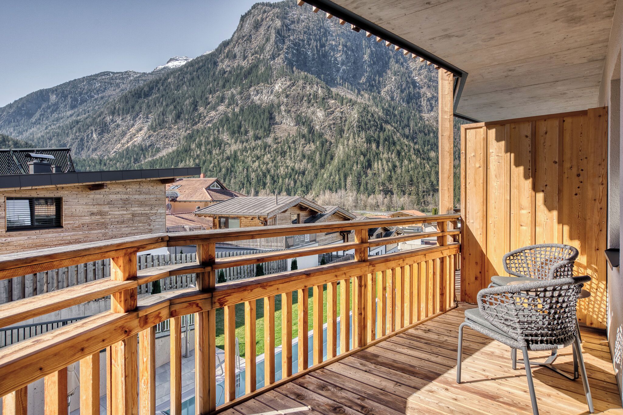 Una terraza de madera con vistas a las montañas.