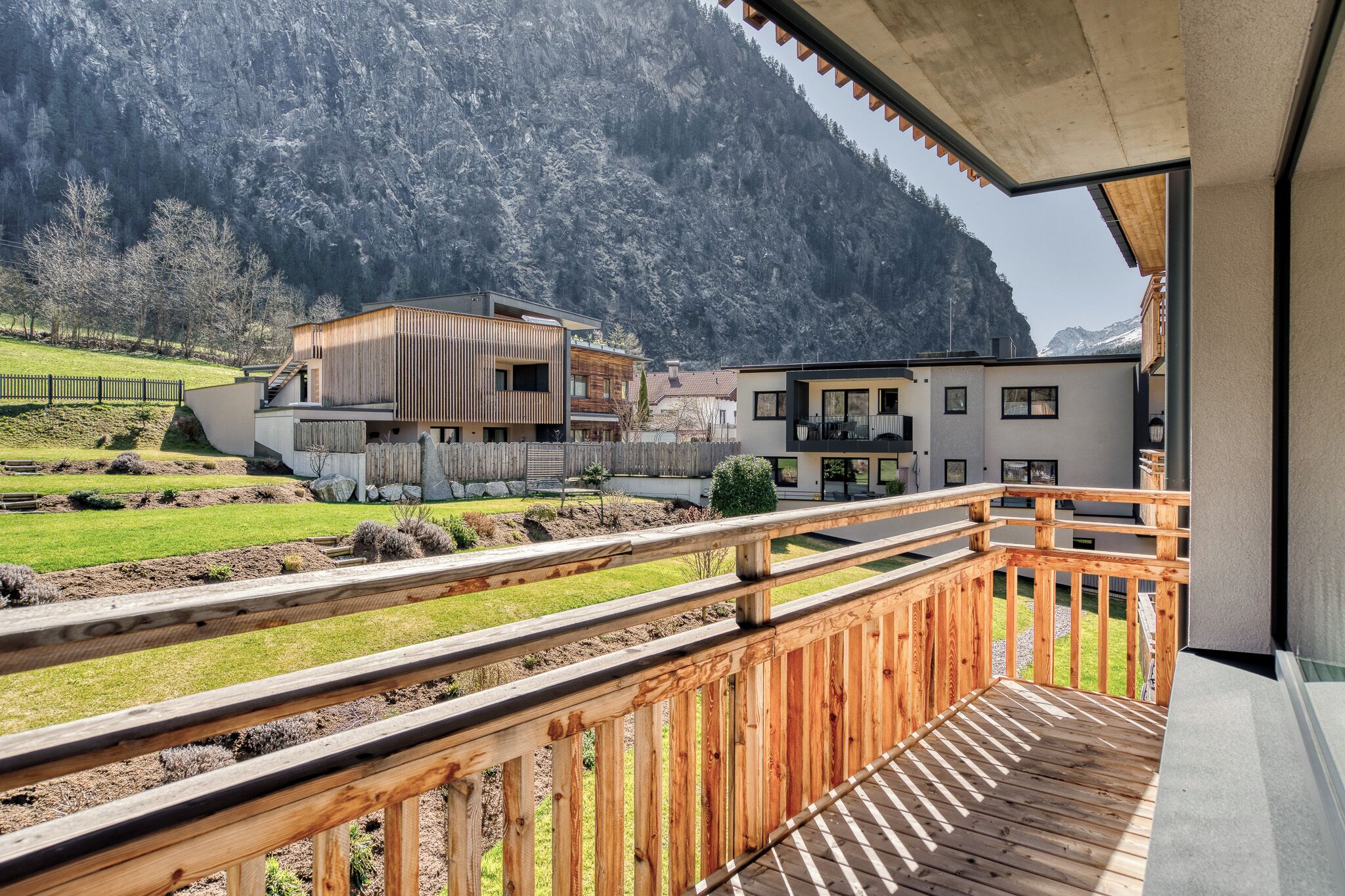 A wooden deck with a view of a mountain and buildings in the background.