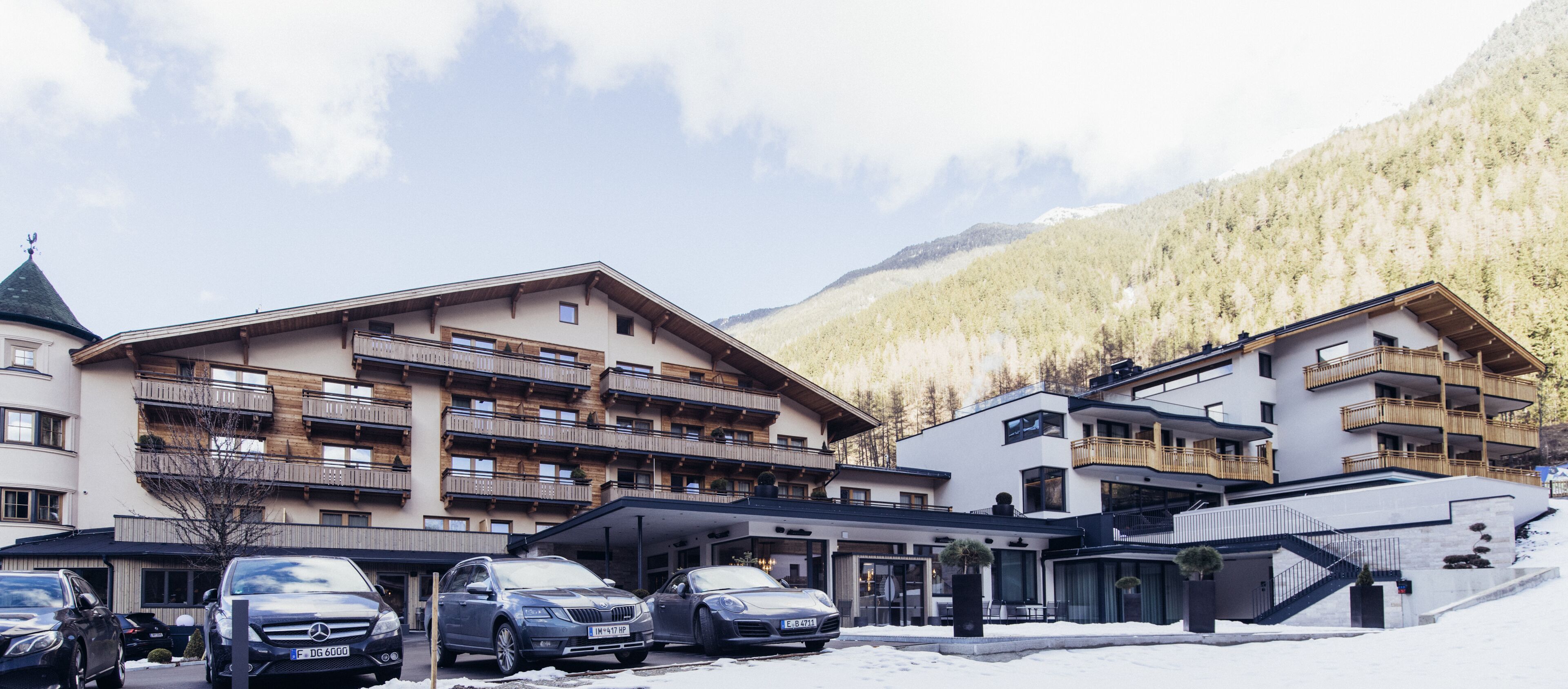 A hotel with multiple floors, balconies, and a ski slope.