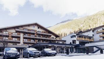 A hotel with multiple floors, balconies, and a ski slope.