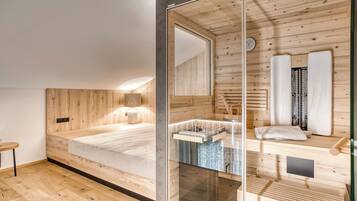 Un dormitorio moderno con pared de listones de madera, cabina de ducha de vidrio y suelo de madera.