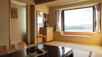 Una habitación con una mesa de comedor, sillas, un armario pequeño y una ventana con vistas.