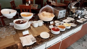 A buffet setup with various food items and utensils. - PJ Watergate Hotel (Bangkok)