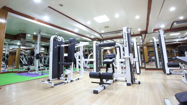A gym with various exercise machines, mirrors, and a wooden floor. - PJ Watergate Hotel (Bangkok)