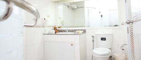 Un baño con inodoro, lavabo y ducha.