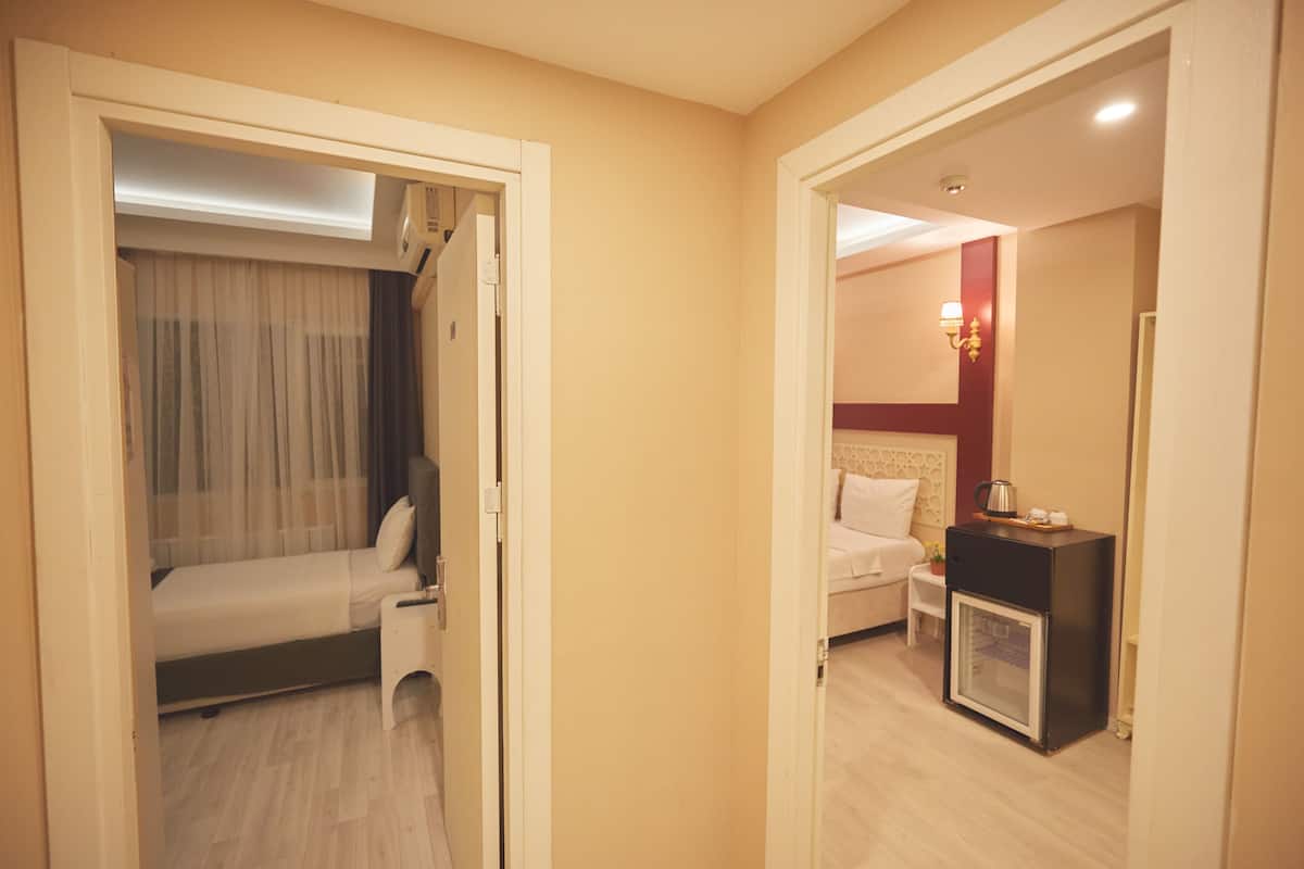 Ein Hotelzimmer mit Bett, kleinem Tisch, Nachttisch, Schrank und einer Wandleuchte.