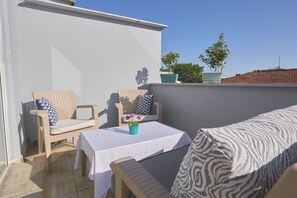 Familiekamer, 2 queensize bedden, balkon, gedeeltelijk uitzicht op zee | Woonruimte | Een 32-inch lcd-televisie met satellietzenders, televisie en boeken