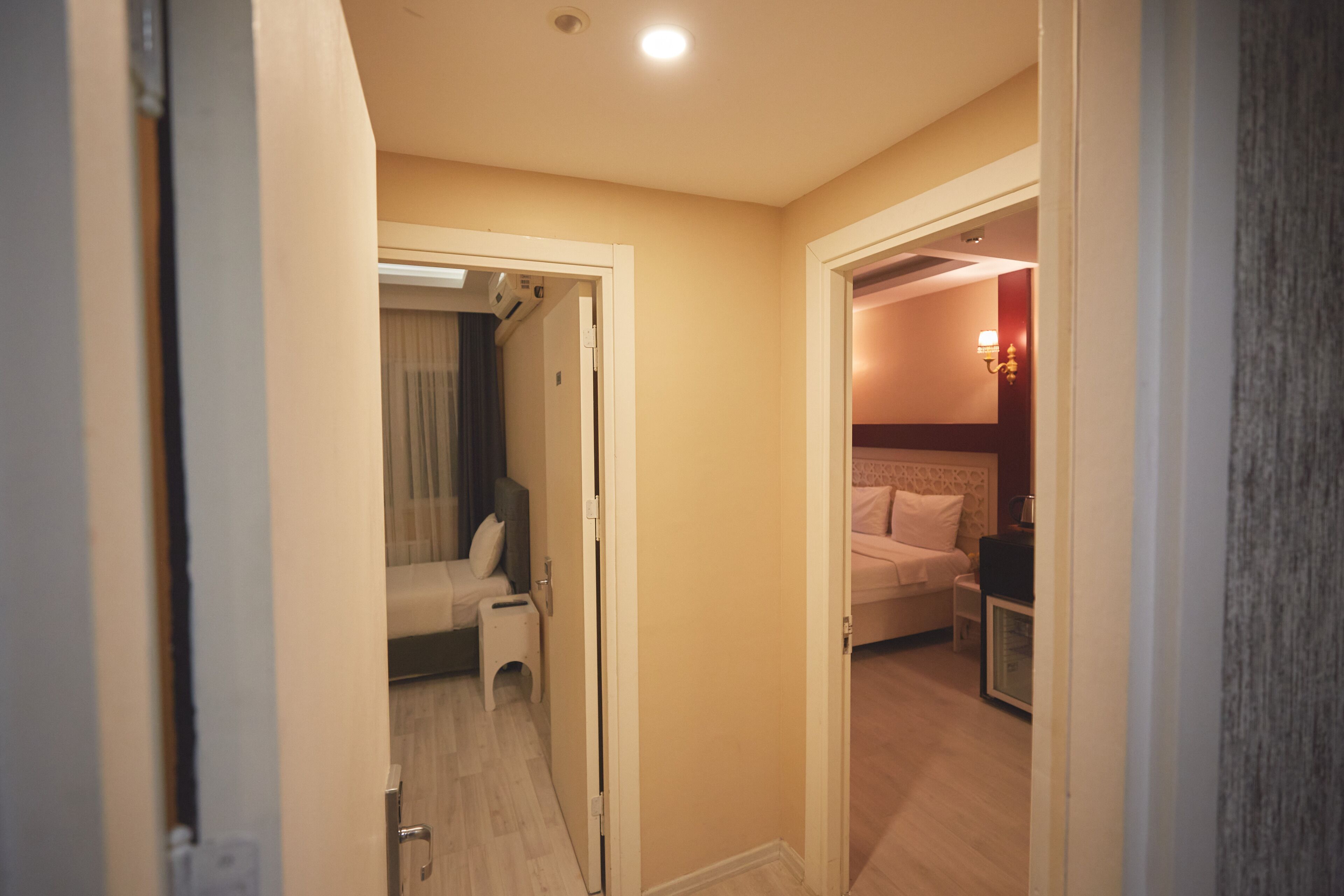 A hotel room with a bed, bedside table, and a small seating area with a chair and a table.