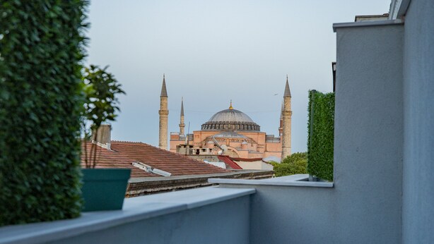 A dining table with a view of a mosque with two minarets and a dome. - Albatros Hagia Sophia - Special Class (Istanbul)