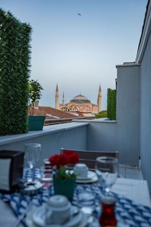 A dining table with a view of a mosque with two minarets and a dome. - Albatros Hagia Sophia - Special Class (Istanbul)