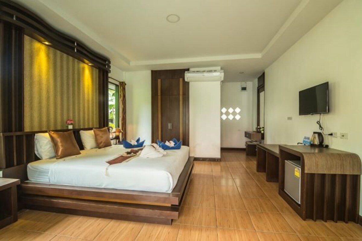 Habitación de hotel con cama, televisión, escritorio y baño.