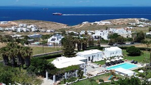 Una zona residencial costera con edificios blancos, una piscina y vista al mar.