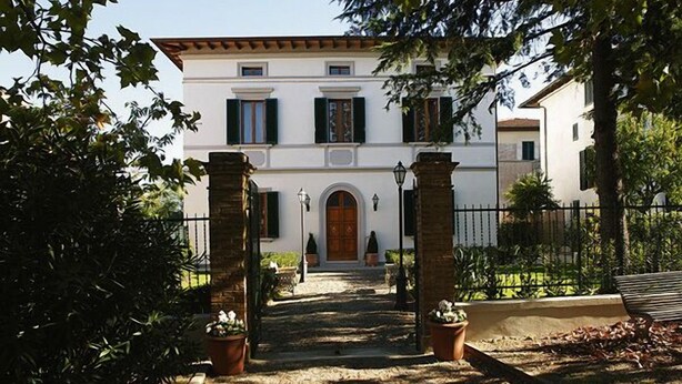 A building with a central entrance, flanked by two columns, leading to a door with a small porch area. - Villa della Certosa (Gambassi Terme)