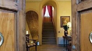 A wooden staircase leading to an upper floor, flanked by wooden doors with metal handles. - Villa della Certosa (Gambassi Terme)