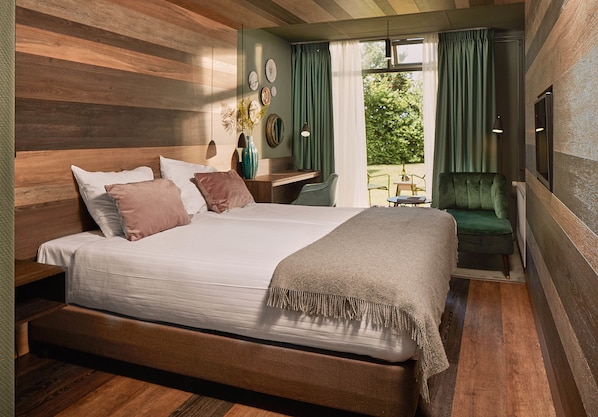 Un dormitorio moderno con una cama grande, un escritorio y vistas al exterior.