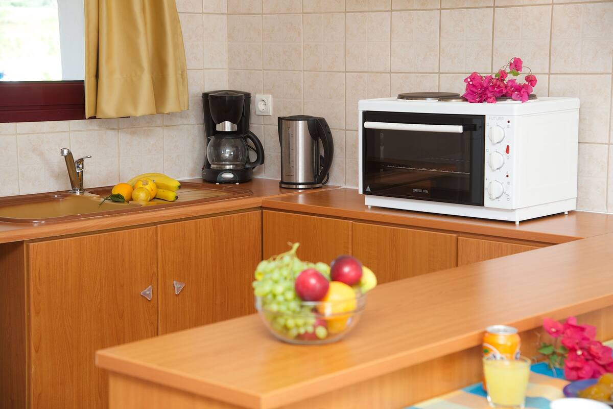 Une cuisine équipée d’une machine à café, d’un grille-pain et d’un panier à fruits.