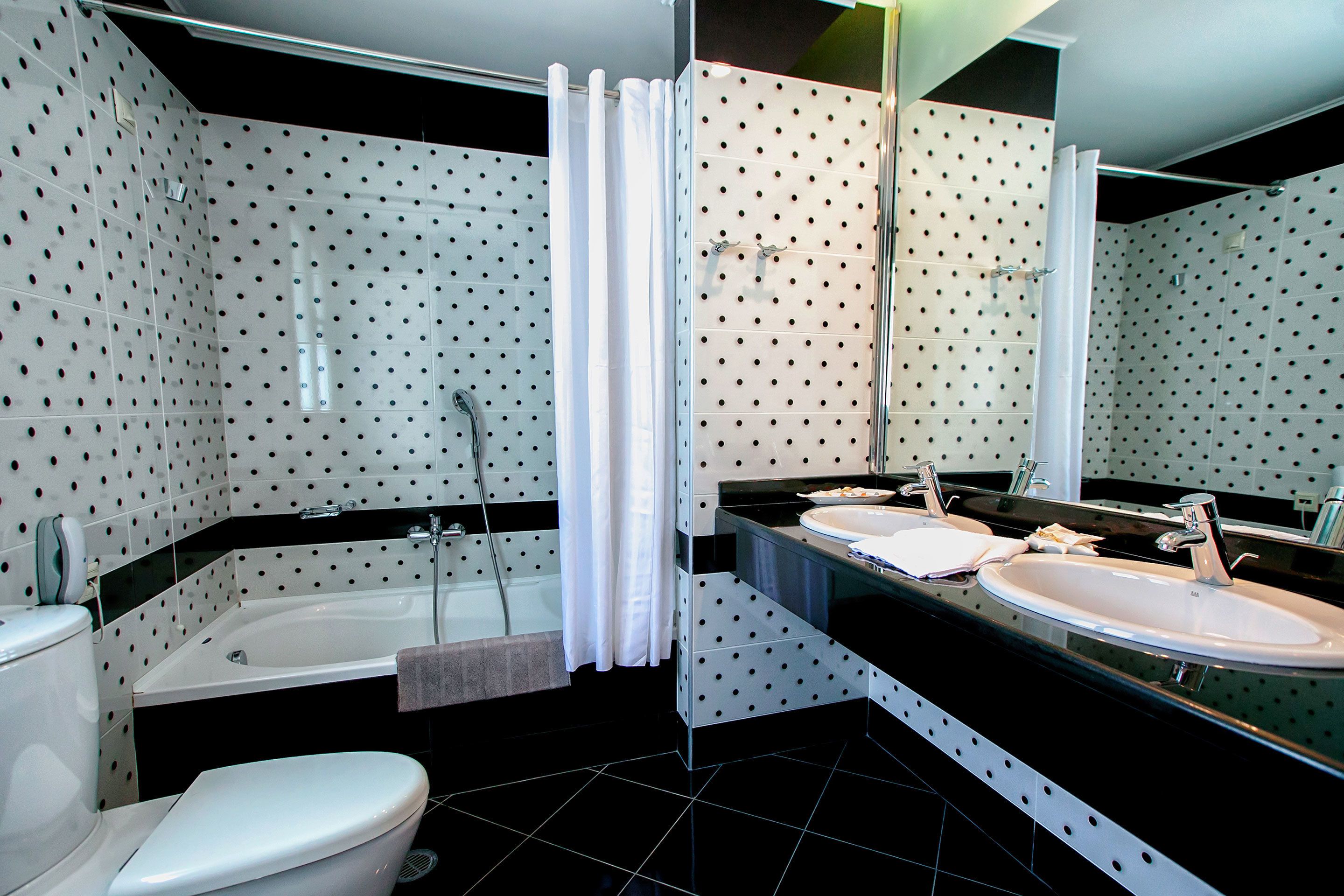deluxe suite | bathroom | combined shower/bathtub, rainfall showerhead, designer toiletries