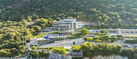 A coastal hotel with multiple buildings, a marina, and a beach area.