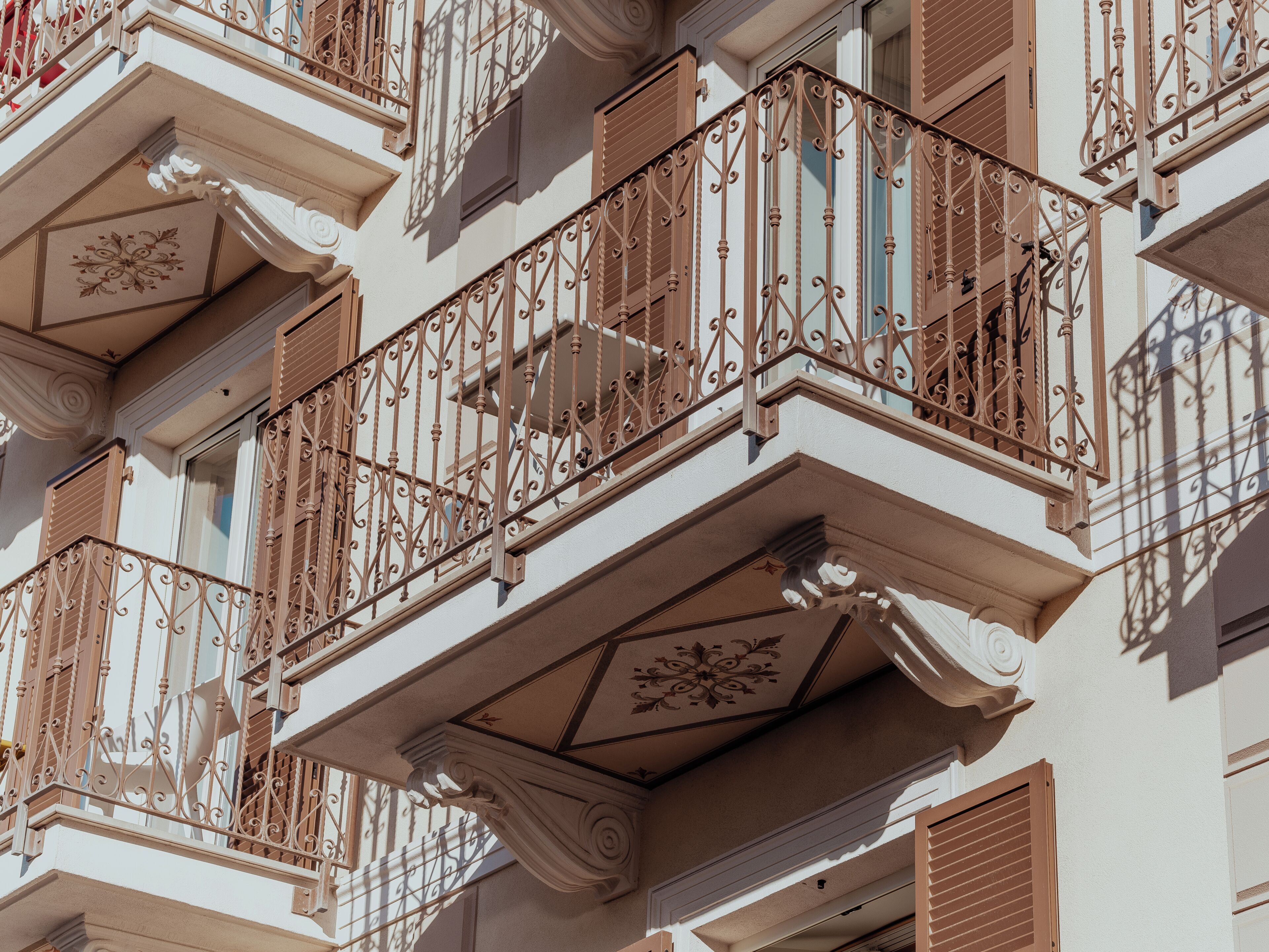 A building facade with ornate balconies, decorative moldings, and a symmetrical architectural design.