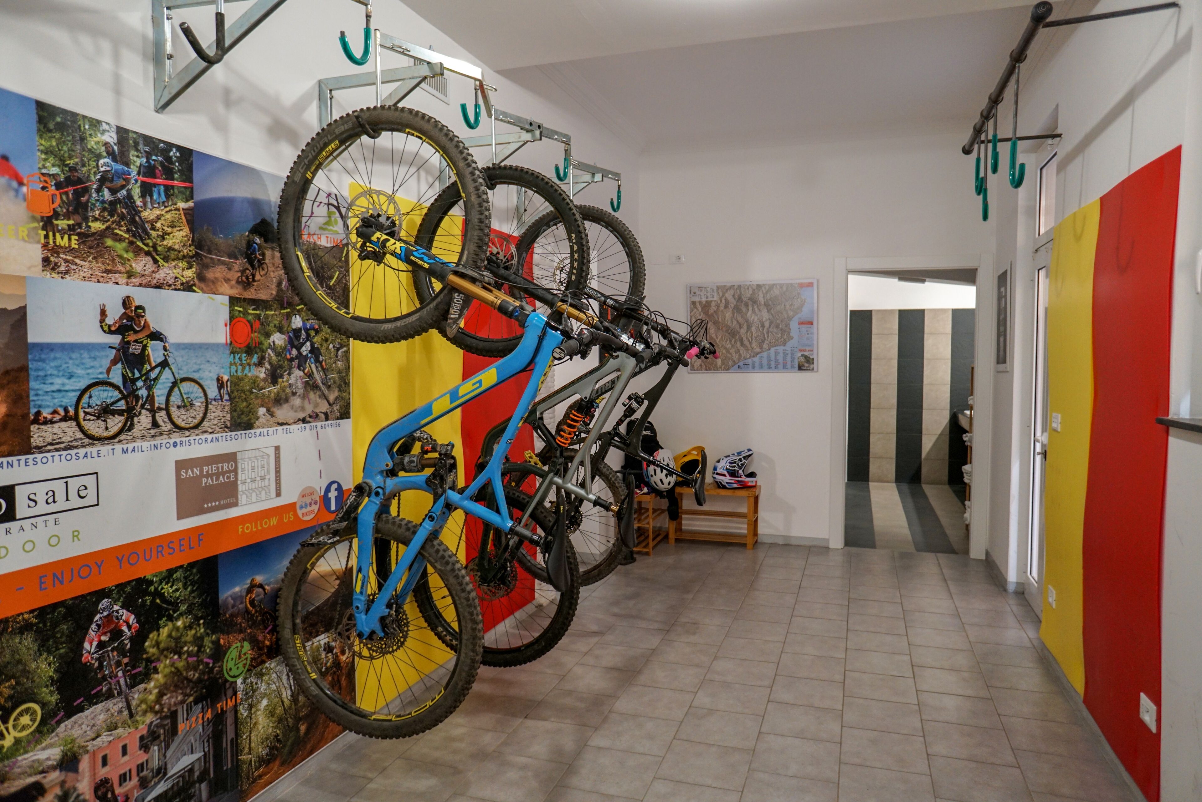 A hallway with bicycles mounted on a rack, a wooden bench, and a door leading to another room.