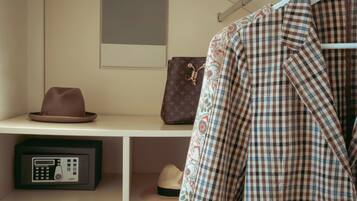 Un armadio con una rastrelliera, un cappello, una giacca fantasia e una borsa Louis Vuitton.