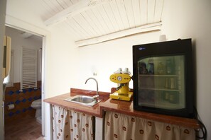 A kitchen with a sink, a yellow coffee machine, and a refrigerator. - Gran Maestro B&B (Palermo)