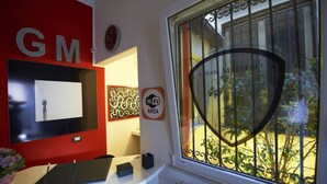 A hotel reception area with a red wall, a clock, and a Wi-Fi sign. - Gran Maestro B&B (Palermo)