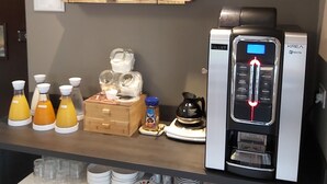 A kitchenette with a coffee maker, a refrigerator, and various kitchenware.