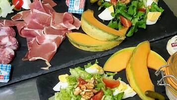 A charcuterie board with various meats, cheeses, and fruits.
