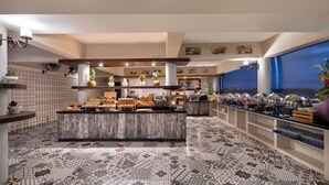 Une cuisine moderne dotée d’un îlot central, de divers appareils électroménagers et d’un sol à motifs.