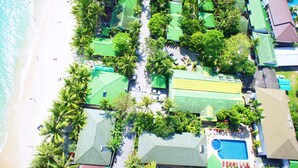 An aerial view of a resort with multiple green-roofed buildings, a swimming pool, and a beach. - Lamai Inn 99 Bungalows (Koh Samui)