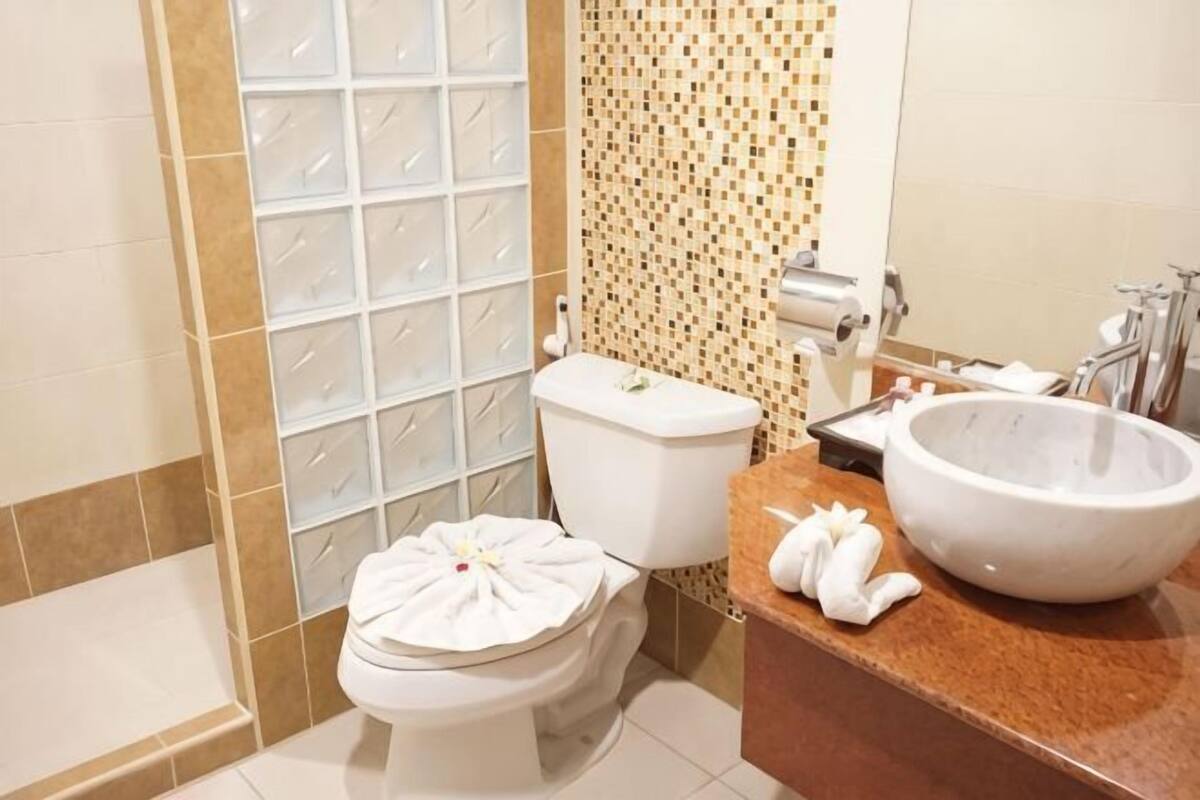 Une salle de bain comprenant des toilettes, un lavabo et un espace douche.