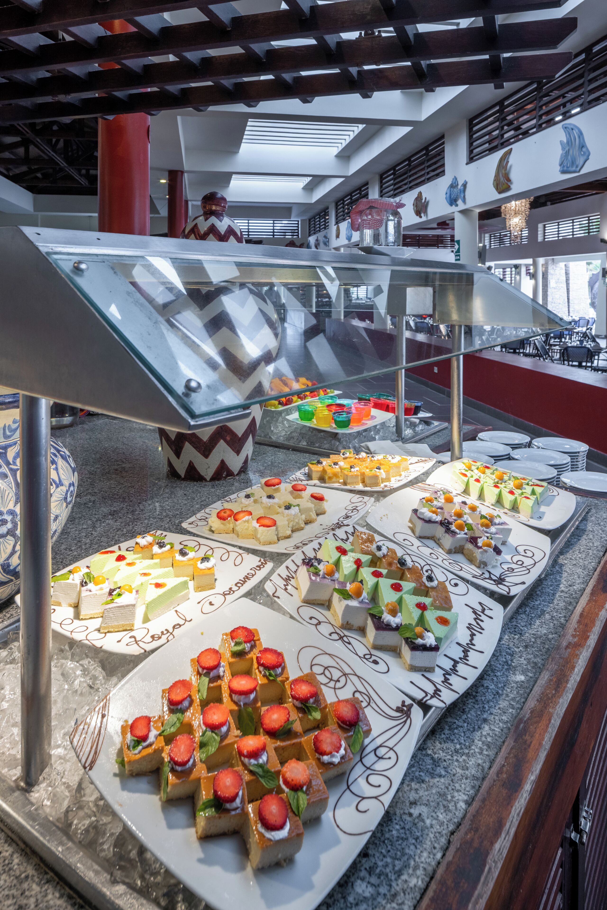 A buffet with various desserts and a glass display case.