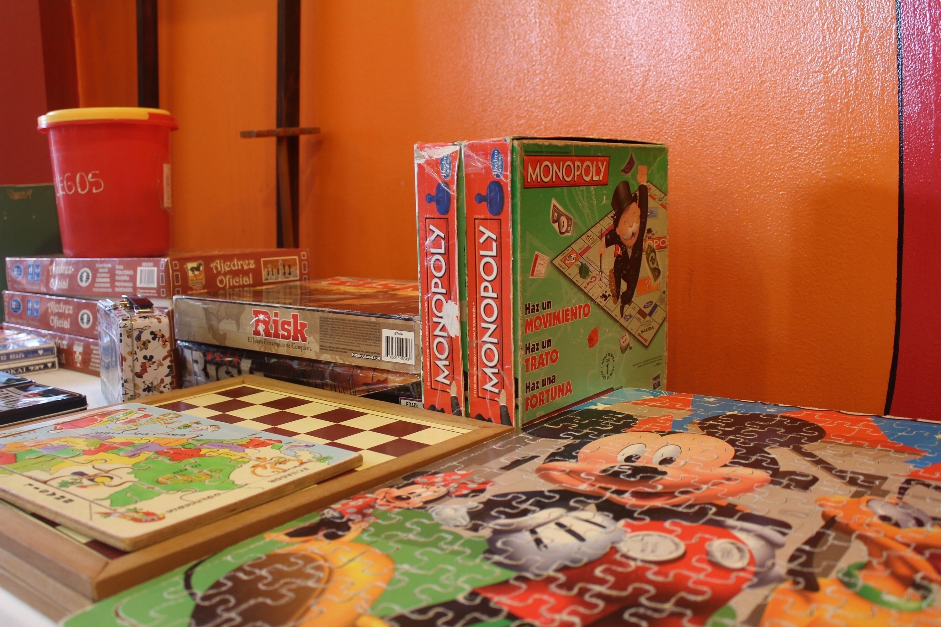 Un jeu de société Monopoly, dont le plateau est posé sur une table et présente un motif coloré en forme de pièces de puzzle.