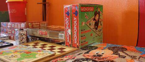 Un jeu de société Monopoly, dont le plateau est posé sur une table et présente un motif coloré en forme de pièces de puzzle.
