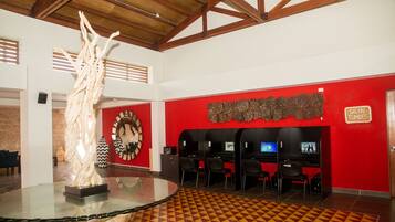Un vestíbulo con una mesa de vidrio, paredes rojas, un reloj y un letrero que dice "SALON TUMBES".