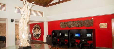 A lobby with a glass table, red walls, a clock, and a sign reading "SALON TUMBES".